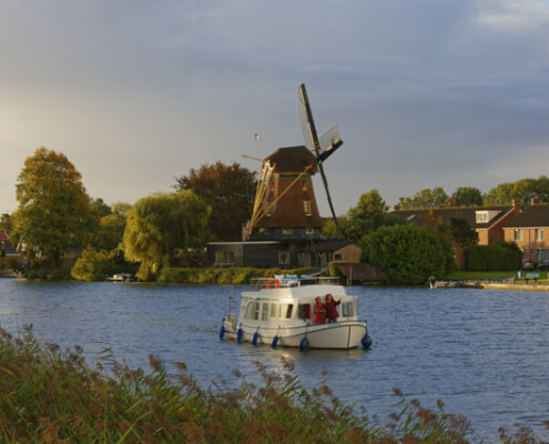 Hausboot vor Windmühlen in Holland