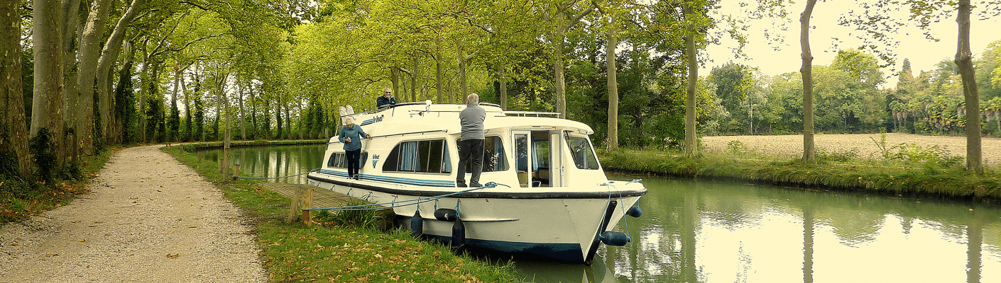 Hausboot am Kanal du Midi zwischen Platanen
